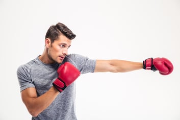 Side view portrait of a handsome man boxing isolated on a white background